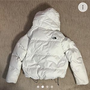 White North Face puffer jacket with a detachable fur hood.